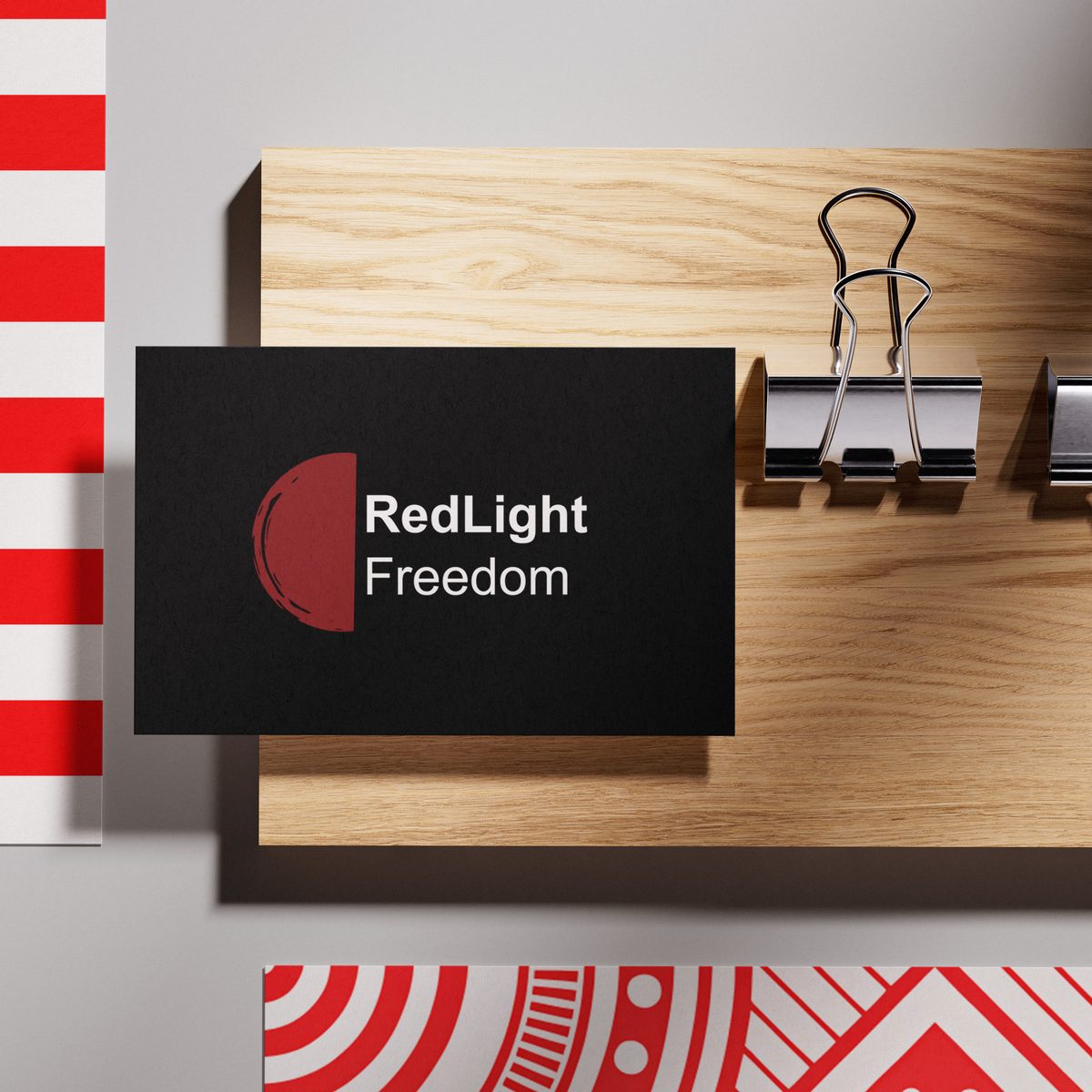 RedLight Freedom — anti-trafficking advocacy brand business card on red and wood
